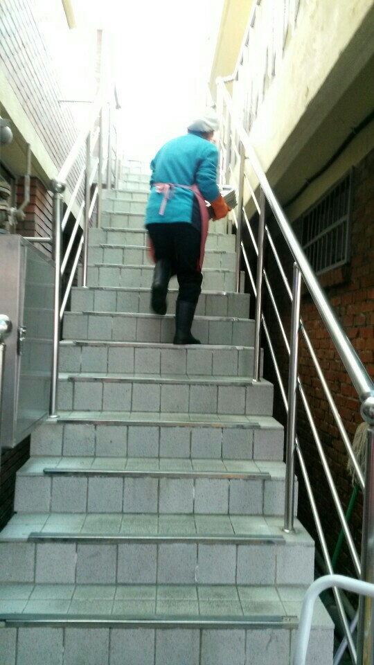 무거운 식판을 들고 계단을 수없이 오르내려야 하는 급식 노동자의 모습. 전국학교비정규직노조 강원지부