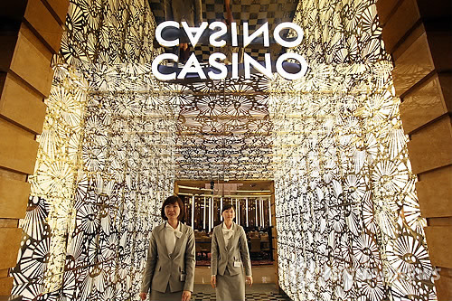 Two employees of the foreigners-only Seven Luck Casino in Seoul, run by GKL, welcome visitors. (Yonhap)