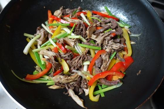 양념해 재운 소고기와 조선간장(또는 액젓)으로 간한 싸리버섯을 팬에서 들기름으로 볶다가 파프리카·쪽파를 넣고 다시 볶고 있다.