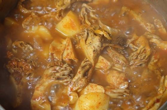 삶아 우리고 물기를 꼭 짠 싸리버섯과 돼지고기에 고추장을 버무려 볶다가 물을 약간 붓고 감자 넣고 찌개 밑재료를 익히고 있다.