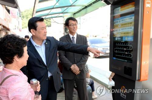 (공주=연합뉴스) 오시덕 충남 공주시장(가운데)이 1일 공주시 시내버스 터미널 정류장에서 이날 개통한 버스정보시스템을 시민과 함께 살피고 있다. 2017.9.1 [공주시 제공=연합뉴스]