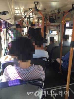버스 승객들이 버스가 정차하기 전 미리 하차문 앞에 서 있다./사진=남형도 기자