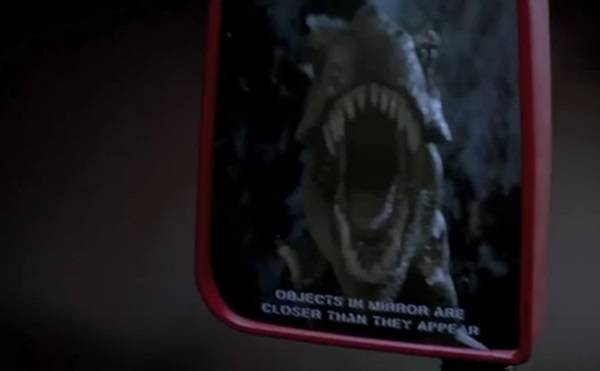 영화 쥬라기공원에서 티라노사우루스가 지프를 타고 도망가는 사람들을 뒤쫓는 장면. 자동차 백미러에 비친 티라노사우루스의 모습이다. 사진=유니버설픽처스