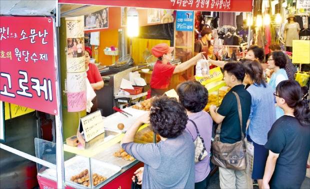 백화점과 대형마트 입점을 알리는 플래카드를 내건 ‘원당수제 고로케’ 점포에 장보러 나온 주부들이 몰려있다. 강은구 기자 egkang@hankyung.com
