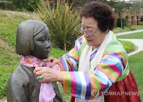 일본군 위안부 피해자인 이용수 씨가 2015년 5월 6일(현지시간) 미국 캘리포니아 주 글렌데일 시립공원에 세워진 '평화의 소녀상'에 분홍색 스카프를 감아주고 있다.