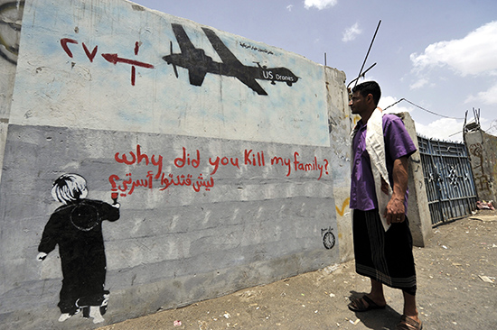 ⓒEPA : 한 남성이 예멘 수도 사나의 벽에 붙은 미군 드론 비판 벽화를 바라보고 있다.