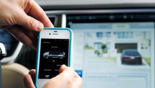 테슬라 디자인센터에서 애플 아이폰 앱으로 차량을 제어하는 기술을 시연하고 있다./조선일보DB