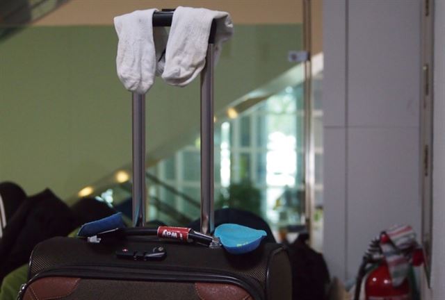 25일 새벽 공항 한편의 여행가방 손잡이에 양말이 널려있다. 뒤편의 소화기에도 널려 있다.