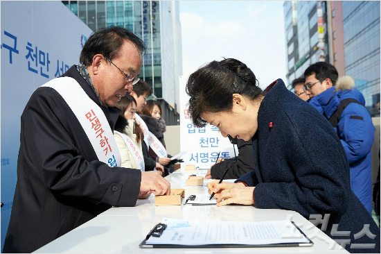 박근혜 대통령이 18일 대한상공회의소 등이 벌이고 있는 ‘민생구하기 입법촉구 1000만 서명운동’에 서명하고 있다.  (사진=청와대 제공)