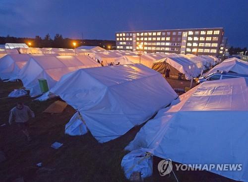2015년 9월1일(현지시간) 독일 중부 할버슈타트에서 망명 신청자들이 머물고 있는 난민촌의 텐트 사이를 한 남자가 걸어가고 있다. AP=연합뉴스 자료사진)
