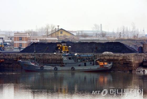 유엔 대북 제재안이 효력을 발휘한지 하루가 지난 4일 오후 중국 랴오닝성 단둥시 외곽 지역인 동강에서 바라본 북한의 작은 포구에 무연탄을 정리하는 사람들이 보인다. /사진=머니투데이