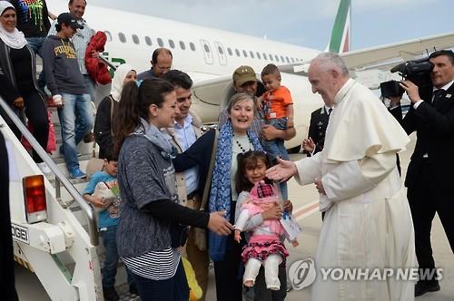 교황이 그리스 레스보스섬에서 온 시리아 난민들을 로마 공항에서 맞이하고 있는 모습. [AFP=연합뉴스]