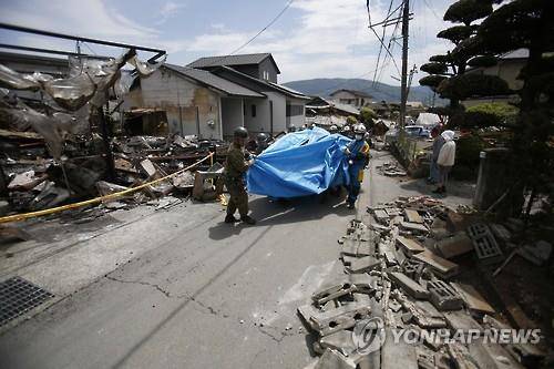 (구마모토 AP=연합뉴스) 연쇄 강진이 강타한 일본 구마모토현에 파견된 재해 대응팀이 16일 폐허가 된 건물 사이에서 작업 중이다.