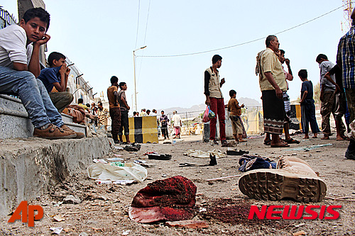 【아덴=AP/뉴시스】예멘 남부 도시 아덴에서 23일(현지시간) 자살 폭탄 테러가 2차례 연속 발생해 최소 45명이 숨졌다.사진은 자폭테러 현장에서 한 소년이 피묻은 모자와 나뒹구는 신발 등을 무심하게 쳐다보는 모습. 2016.05.23