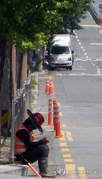 경남 폭염주의보 (창원=연합뉴스) 이정훈 기자 = 30일 창녕군의 낮 최고기온이 33.3도까지 오르는 등 경남 내륙지역에 올들어 첫 폭염주의보가 내린 가운데 창원시 의창구의 한 아파트 공사현장 주변 도로에서 현장직원 1명이 챙이 있는 모자와 햇빛 가리개로 얼굴을 감싼 채 가로수 그늘에 앉아 쉬고 있다. 창원시는 이날 낮 최고기온이 31.3도까지 올랐다. 2016.5.30 seaman@yna.co.kr