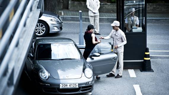 갤러리아 명품관 주차요원이 쇼핑을 하러 온 고객의 차 문을 열어준 뒤 번호표를 건네고 있다. 토요일 오후 3시경 이곳에서 주차를 돕는 직원은 총 30명이다.