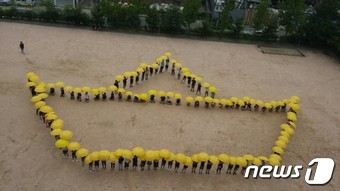 인천 석남중학교 학생들이 13일 학교 운동장에서 세월호 기억 노란우산 프로젝트 플래시몹을 하는 모습. 2016.7.13 © News1 주영민 기자