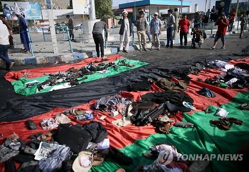 23일 아프가니스탄 카불 시내에서 자폭테러가 벌어진 뒤 유실물이 아프간 국기 위에 놓여있다.(AP=연합뉴스)