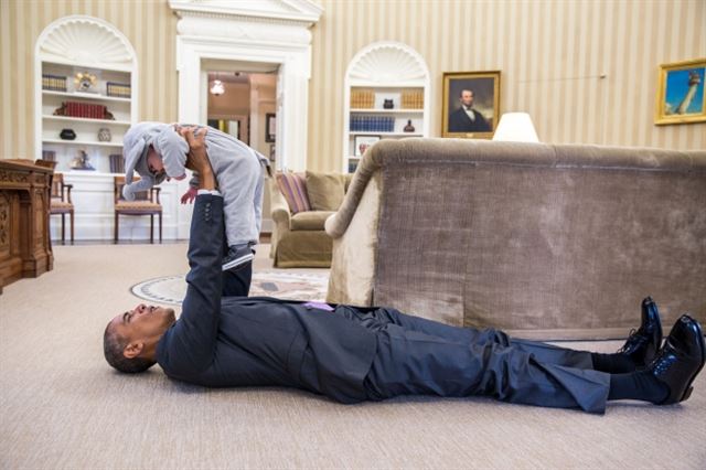 백악관이 공식 홈페이지를 통해 공개한 사진 속에서 버락 오바마 미 대통령이 백악관 집무실에 누워 보좌관의 딸을 번쩍 들어올리고 있다. 백악관 홈페이지