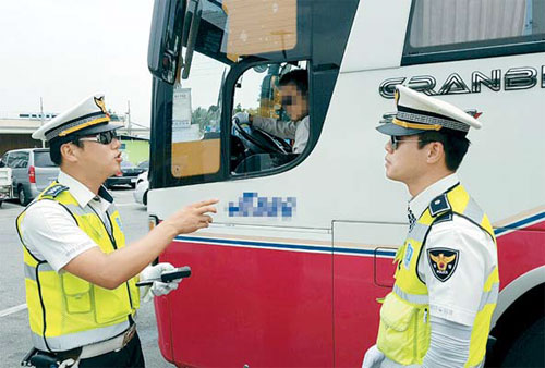 지난 23일 영동고속도로에서 암행순찰을 벌이던 고속도로순찰대 소속 경찰관들이 지정차로를 위반한 고속버스를 적발해 인근 휴게소에서 운전사를 조사하고 있다.