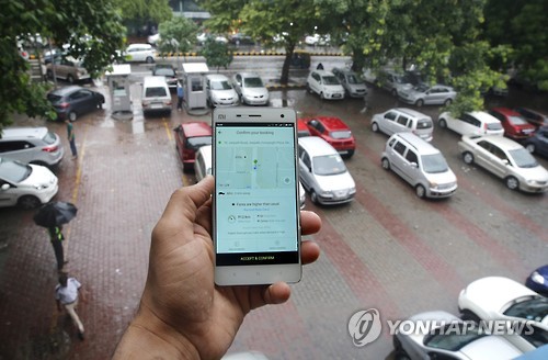 지난해 7월 인도 수도 뉴델리에서 한 남성이 스마트폰으로 택시 앱 '올라'를 이용하고 있다.[EPA=연합뉴스 자료사진]