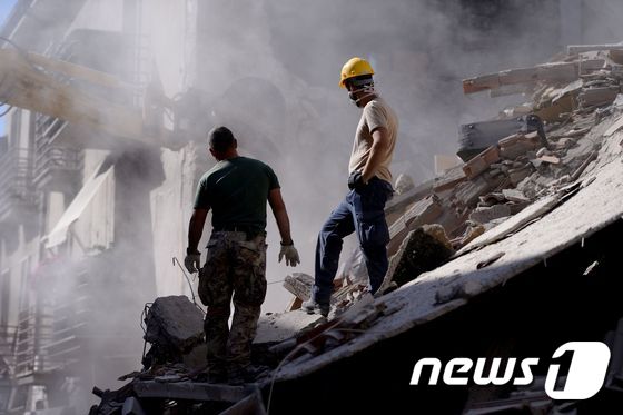 규모 6.2의 지진이 발생한 이탈리아 중부 아마트리체에서 24일(현지시간) 실종자 수색 대원들이 지진으로 인해 무너진 건물 잔해 위를 걷고 있다. © AFP=뉴스1