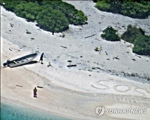 태평양의 무인도에 고립된 선원 2명이 모래 위에 쓴 'SOS'[AP=연합뉴스, 미 해군 제공]