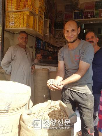 카이로 아타바시장의 한 곡물가게에서 점원이 누에콩을 들어 보이고 있다.