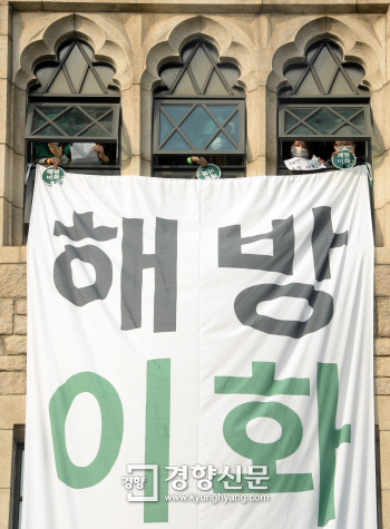 10월 19일 오후 이화여대 교수협의회 소속 교수들이 담화문을 발표하는 동안 본관을 점거중이던 학생들이 피켓을 들고  있다./김정근 기자