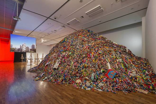 부산비엔날레에 출품된 <파빌리온>은 전 세계에서 모은 종이학 더미 아래 미로 구조물을 배치했다. 관람객들은 컴컴한 이 공간을 지나며 우리 삶을 위협하는 핵무기의 공포를 체감할 수 있다. 부산비엔날레 제공