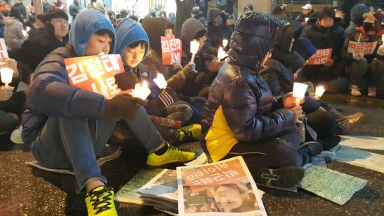 26일 강원도 춘천 김진태 의원 사무실 앞에서 열린 촛불집회에서 학생들이 촛불을 밝히고 있다.