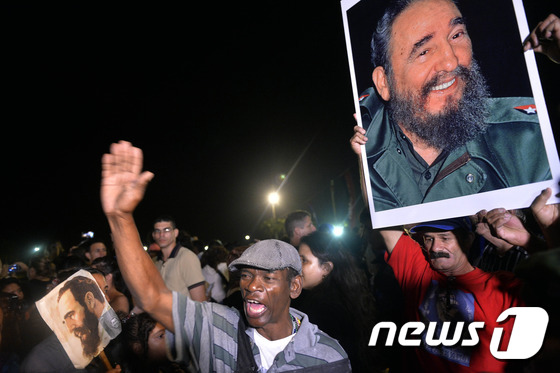 피델 카스트로 전 쿠바 국가평의회 의장의 유해가 담긴 상자를 트레일러 뒤에 단 군용 지프 차량이 1일(현지시간) 새벽 산타클라라에 도착하자 시민들이 '나는 피델이다'고 외치고 있다. © AFP=뉴스1