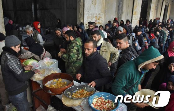 알레포 동부 반군 점령지를 탈출한 주민들이 대피소에서 나눠주는 음식을 먹고 있다. © AFP=뉴스1