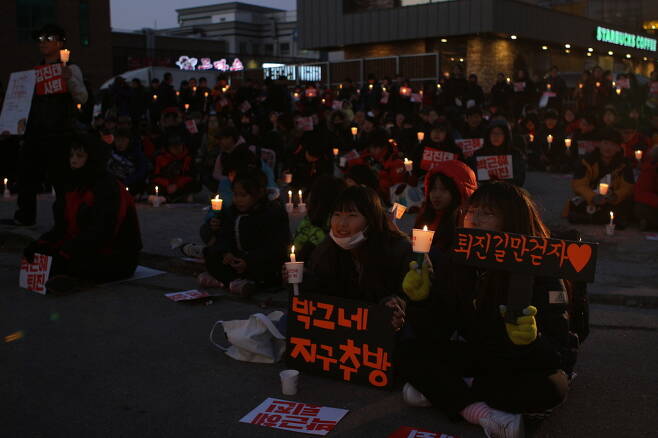 10일 춘천에서 열린 촛불집회에 여학생들이 `박그네 지구추방' `퇴진 길만 걷자'라고 적힌 손팻말을 들고 있다.