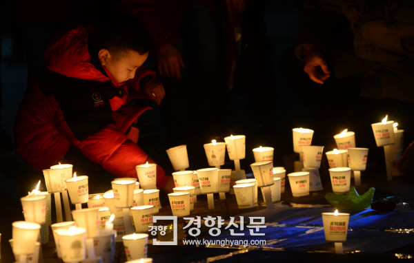 지난해 12월31일 밤에 시작해 새해 2017년 새벽까지 서울 광화문광장에서 열린 제10차 촛불집회에 참여한 한 어린이가 촛불을 밝히고 있다. 김창길 기자 cut@kyunghyang.com