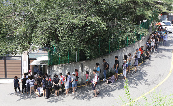 ⓒ연합뉴스 8월4일 주한 중국 대사관 영사부 앞에서 비자를 받으려는 시민들이 길게 줄지어 서 있다. 중국 정부는 한국인에 대한 비자 발급 요건을 까다롭게 조정했다.