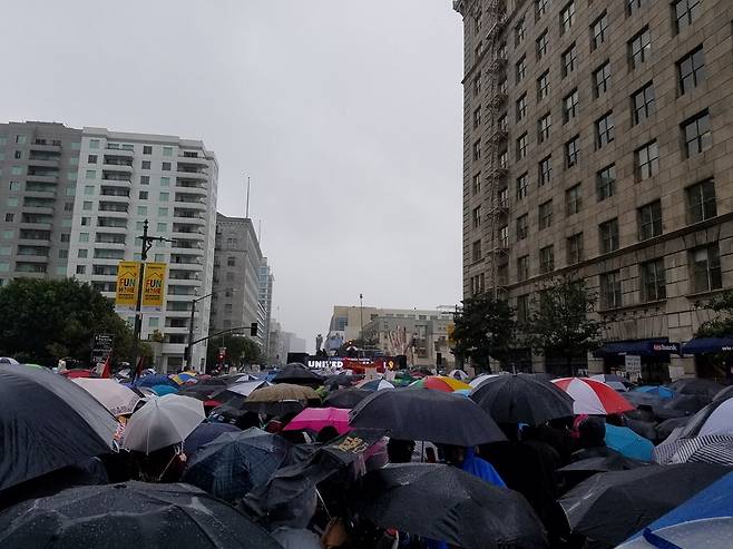 로스앤젤레스에서는 좀처럼 보기 힘든 폭우가 쏟아지는 가운데에도 트럼프 반대 집회에 모인 수천명의 참석자들이 우산을 들고 운집해 있다.