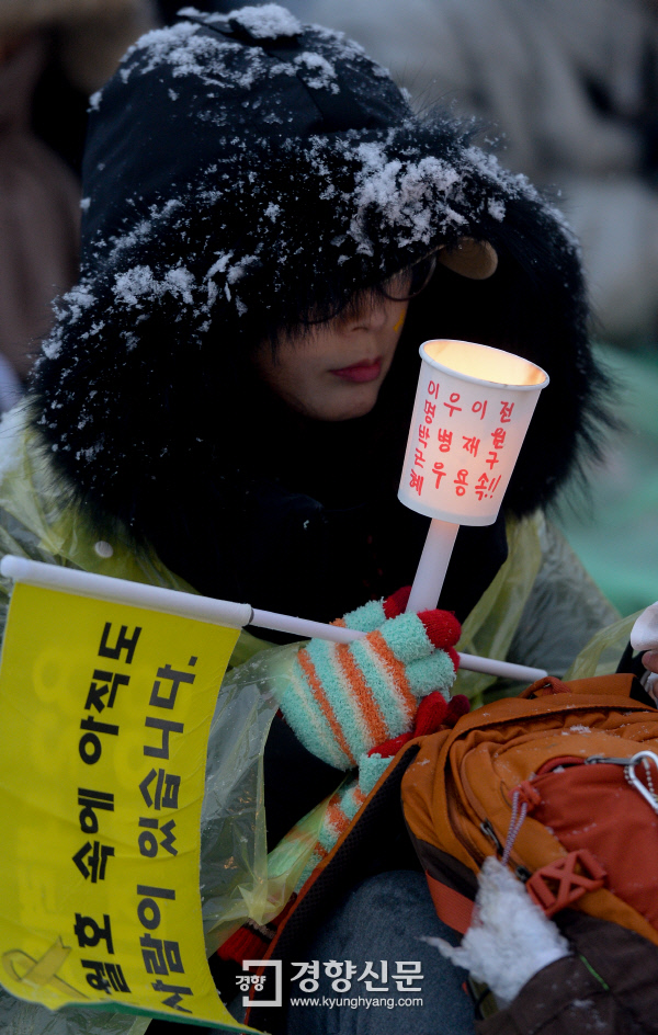 시민들이 21일 많은 눈에도 불구하고 서울 광화문광장에서 열린 촛불집회에 참석하고 있다. 이석우 기자 foto0307@kyunghyang.com