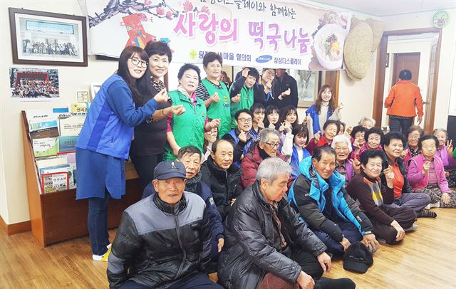 삼성디스플레이 직원들이 23일 충남 아산시 탕정면 마을회관에서 떡국 나눔 봉사 활동을 한 뒤 참석한 노인들과 기념 촬영을 했다. 삼성디스플레이 제공
