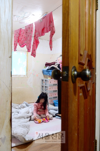 다섯 살 가윤이가 23일 경기 김포시 하성면의 집에서 두툼한 옷을 입고 혼자 장난감을 가지고 놀고 있다.정연호 기자 tpgod@seoul.co.kr