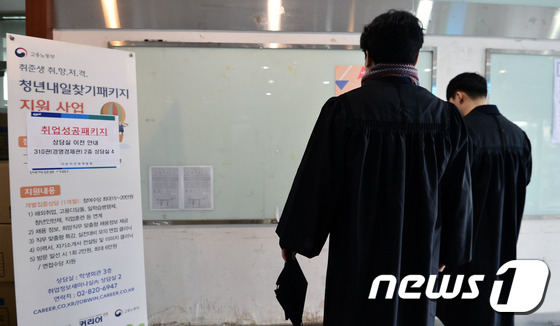 13일 오후 서울의 한 대학교에서 학위수여식을 마친 졸업생들이 텅 빈 취업 게시판을 바라보고 있다./뉴스1 © News1 민경석 기자