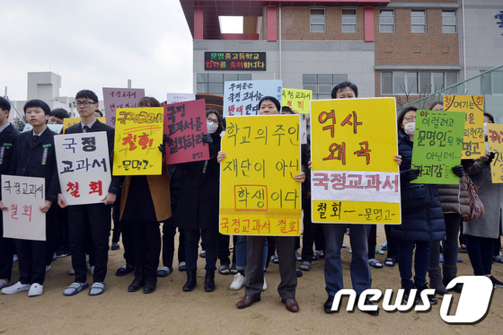경북 경산 문명고 입학식장 앞에서 국정교과서 연구학교 운영에 반대하는 학부모와 신입생들이 피켓을 들고 항의하고 있다./뉴스1 © News1