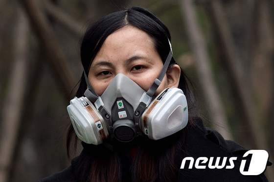 20일(현지시간) 중국 베이징에서 한 여성이 미세먼지를 걸러줄 마스크를 쓰고 길을 걷고 있다. © AFP=뉴스1