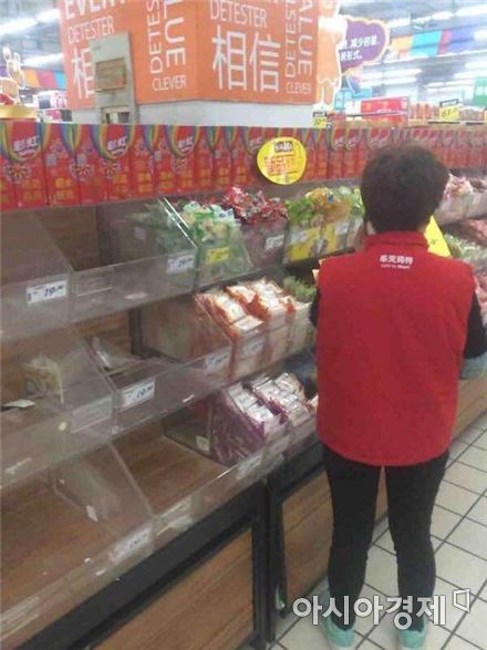 중국 장쑤성 옌첸 롯데마트에서 협력업체 직원이 자사 제품을 빼고 있다.(사진=아시아경제 DB)