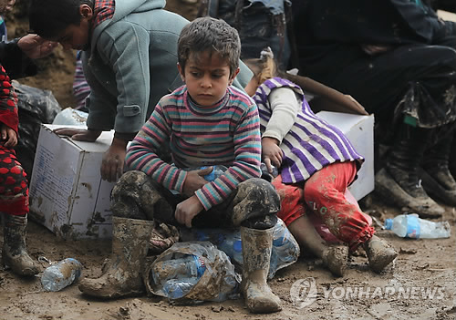 (모술<이라크> AFP=연합뉴스) 20일(현지시간) 이라크 모술 인근 하맘 알-알릴 캠프에서 어린이들이 앉아있는 모습.  현재 이라크군은 수니파 극단주의 무장단체 이슬람국가(IS)가 점령한 모술 서부 지역에 대한 탈환작전을 진행 중이나, 올드시티 등 일부 지구에선 IS 잔존 세력의 거센 저항에 직면해 있다.