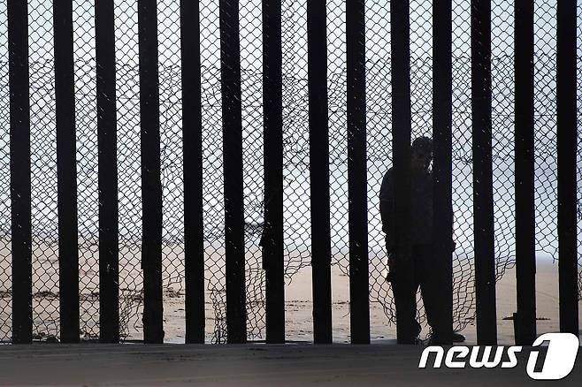 지난 2월13일(현지시간) 촬영된 미국과 멕시코 국경 사진. 한 남성이 멕시코 측 국경에서 미국 영토를 바라보고 있다. © AFP=뉴스1