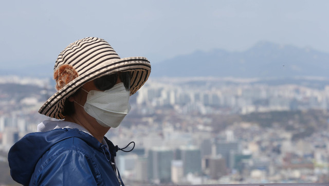 서울 남산에 오른 시민이 미세먼지에 대비해 마스크를 쓰고 도심을 내려다 보고 있다. 신소영 기자 viator@hani.co.kr