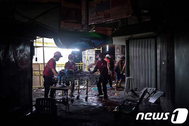 28일(현지시간) 필리핀 마닐라에서 폭탄이 터져 구조 대원들이 구조 작업을 벌이고 있다. © AFP=뉴스1