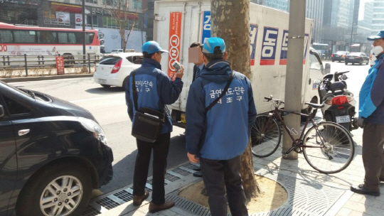 서울 서초구 단속반원들이 지난 3일 강남대로 금연구역에서 담배를 피우던 한 남성을 적발해 위반사실을 고지하고 있다. /박우인기자