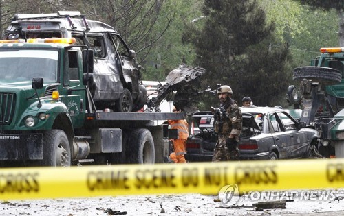 지난 5월 아프가니스탄 수도 카불에서 나토 군 차량을 겨냥한 자폭테러가 벌어진 뒤 경찰이 현장을 조사하고 주변을 정리하고 있다.[EPA=연합뉴스 자료사진]
